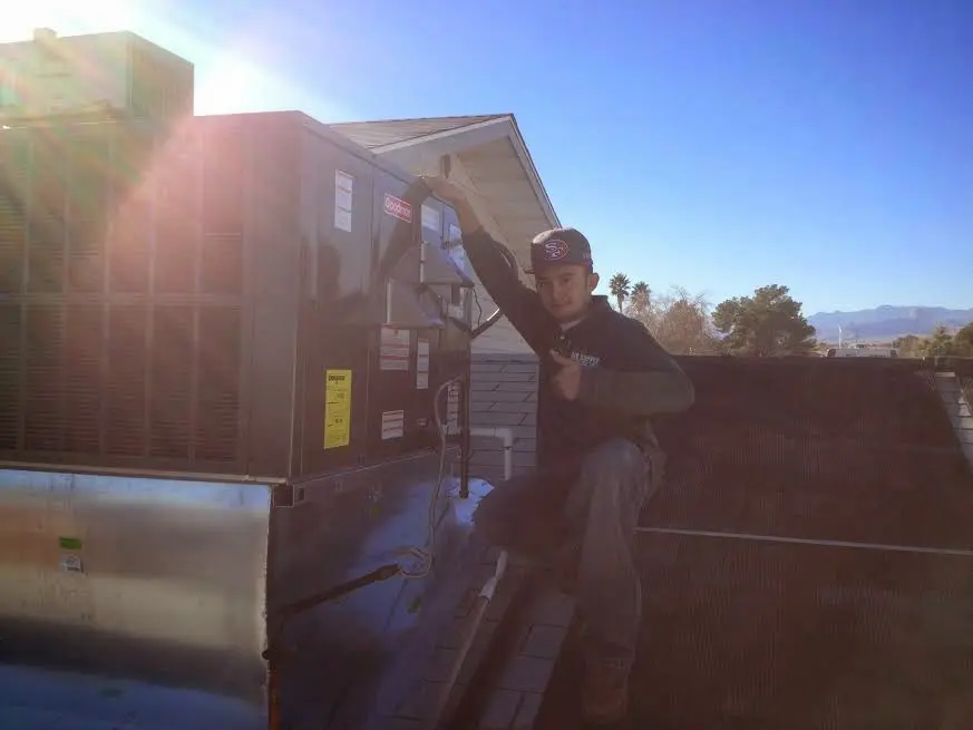 HVAC technician performing AC Tune-Up on a rooftop unit in Bexley
